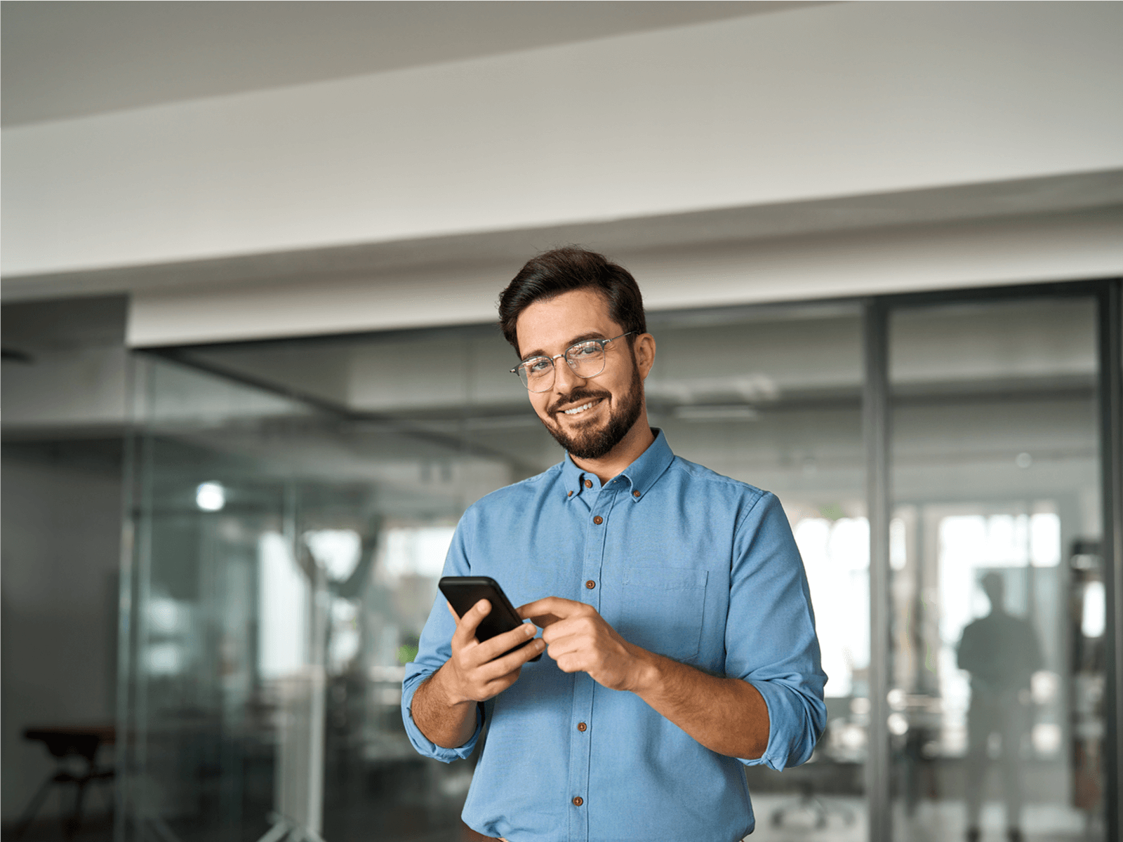 Joven en San José usando su celular para planificar su presupuesto mensual en colones.